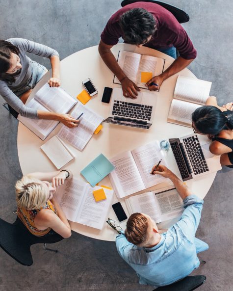 top view of group of students sitting together at table. university students doing group study.